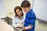 Woman working with elementary student