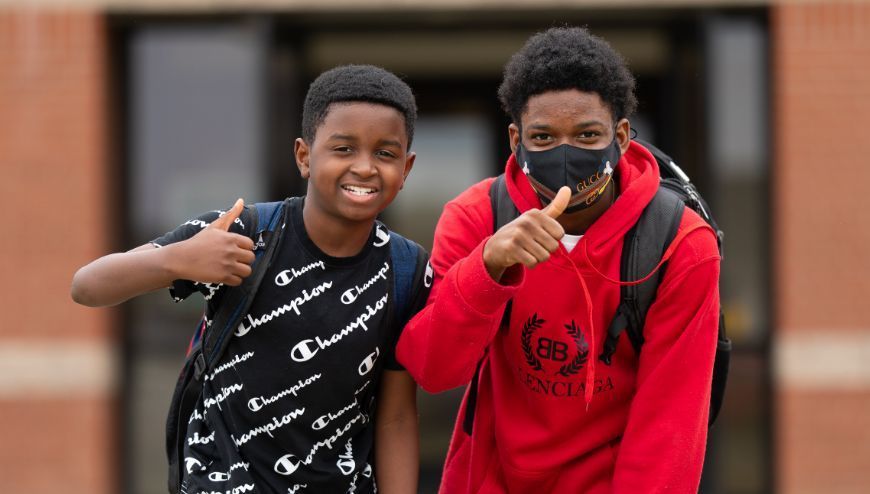 students giving thumbs up