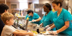 students and cafeteria workers in lunch line