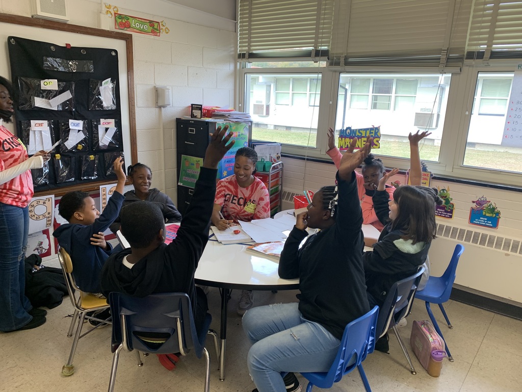 students at round table with volunteer