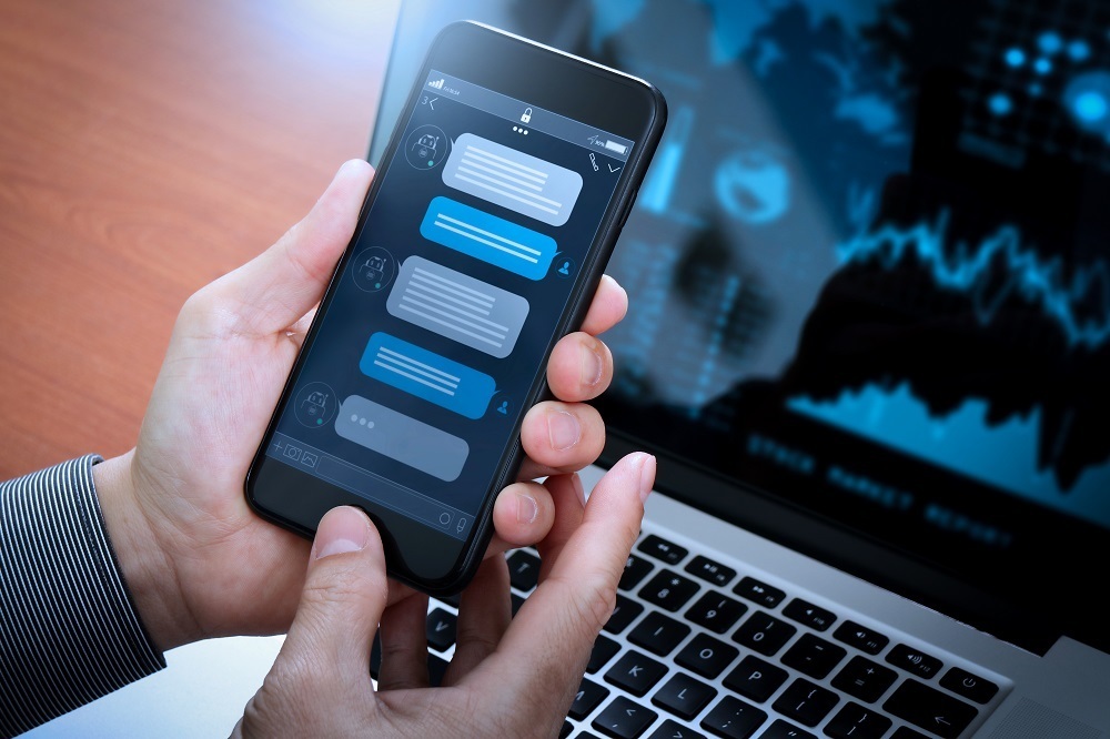 106949089 - Cell Phone with Chat Bubbles in front of Laptop
