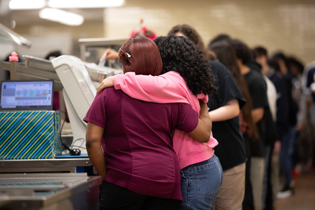 Cafeteria worker and student hugging