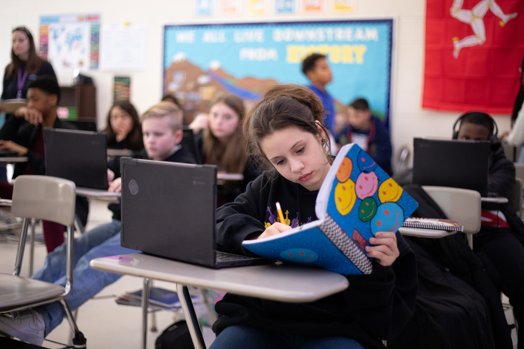 middle school students in class with teacher 