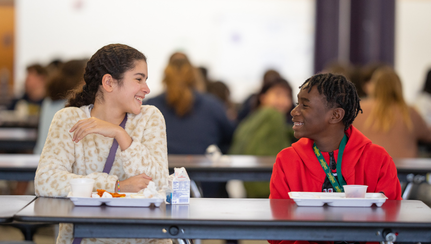 Students sitting at table in cafeteria