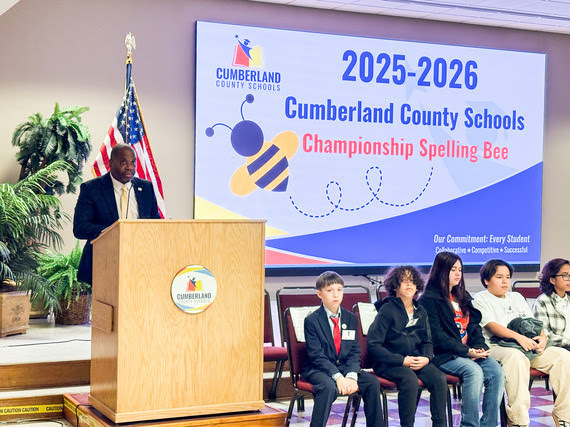 Superintendent Dr. Bracy takes the podium to share words of encouragement with the Spelling Bee participants.