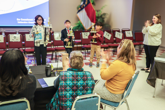 Pictured left to right, Angelika, Leon and Joseph receive applause for their perseverance.