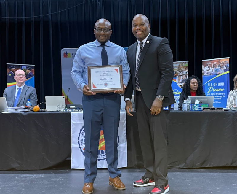 Extra Mile Award Winner Brandon Harvey Stands with CCS Superintendent Dr. Eric Bracy