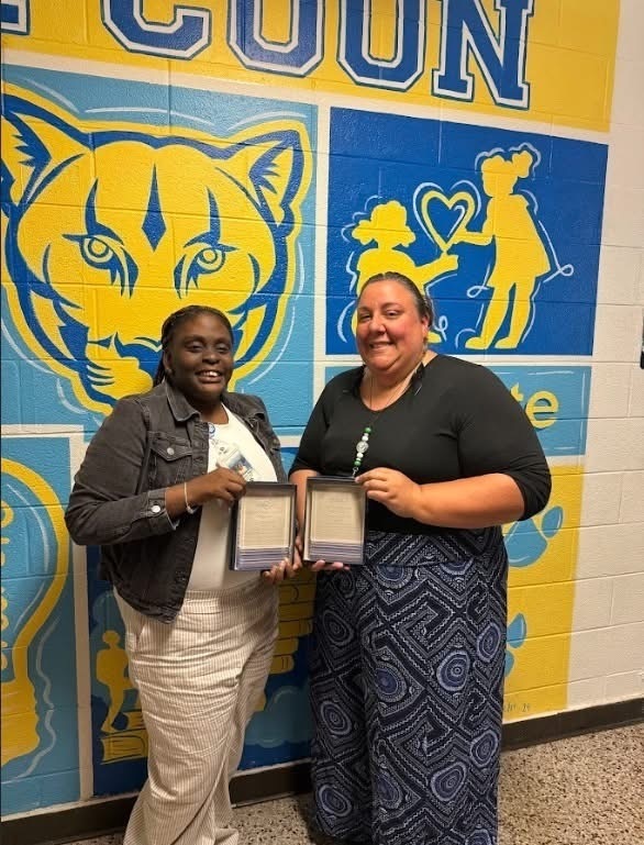 two ladies holding award