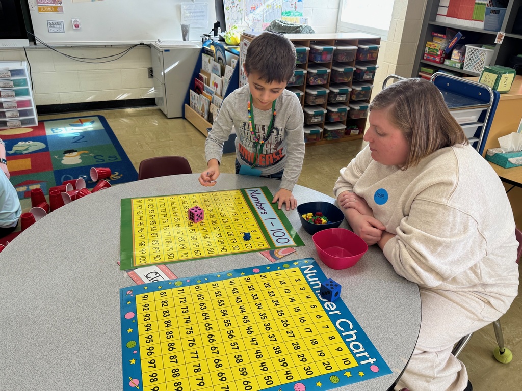 Student rolling a die to move the marker to 100.