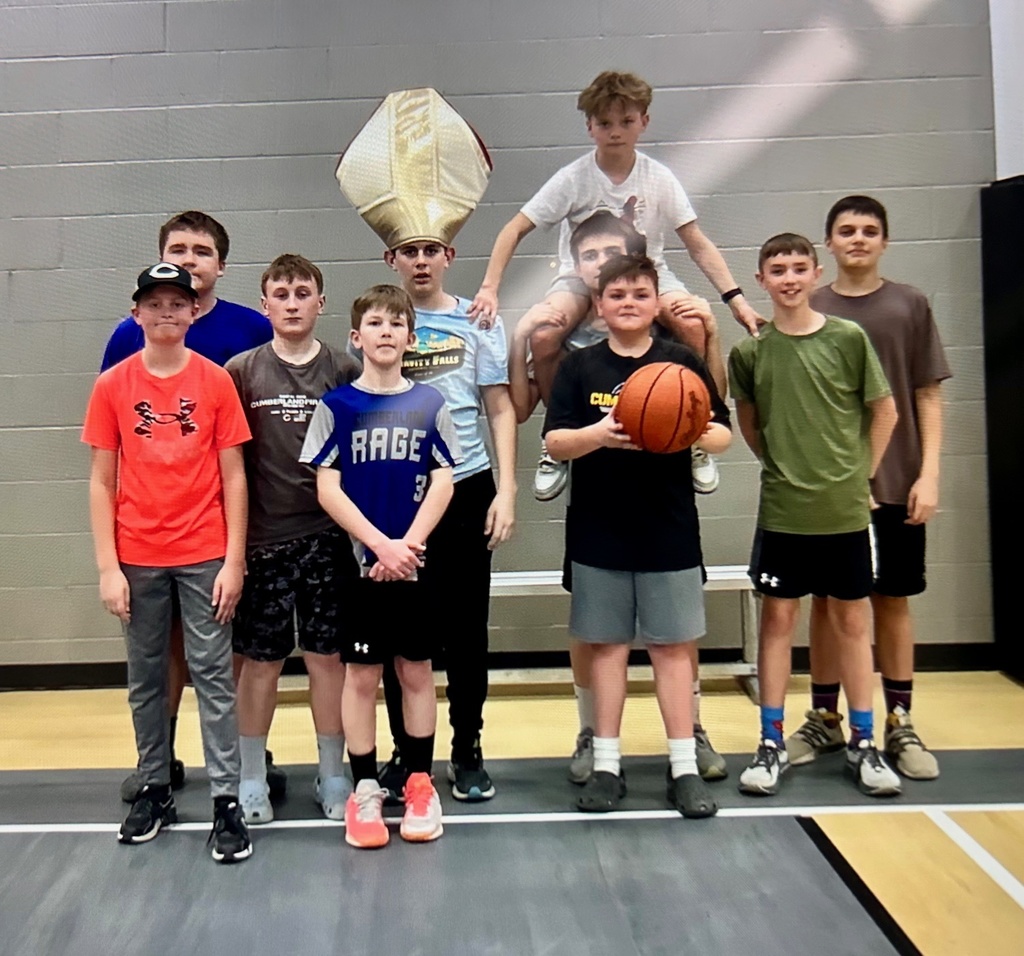 A group of ten students facing the camera. One student is on another's back, one has a pharaoh's hat, and another has a basketball.