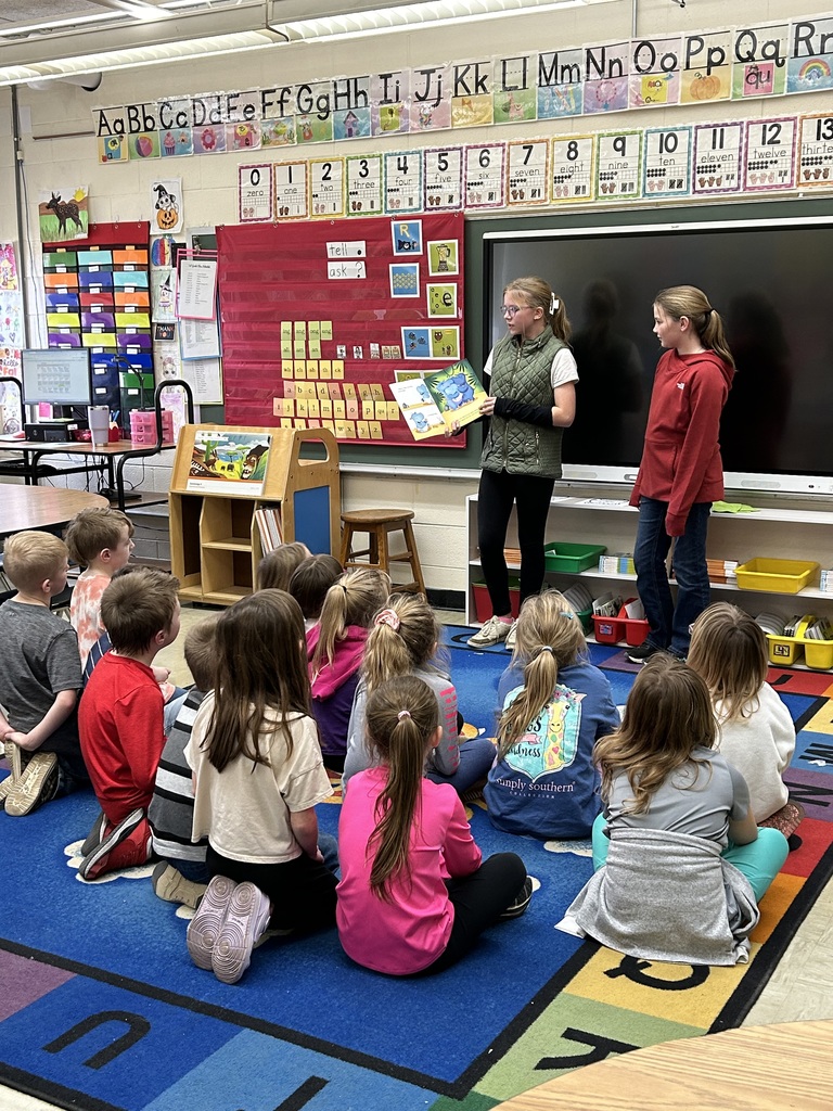 Kindness Ambassadors are reading a story to elementary students.