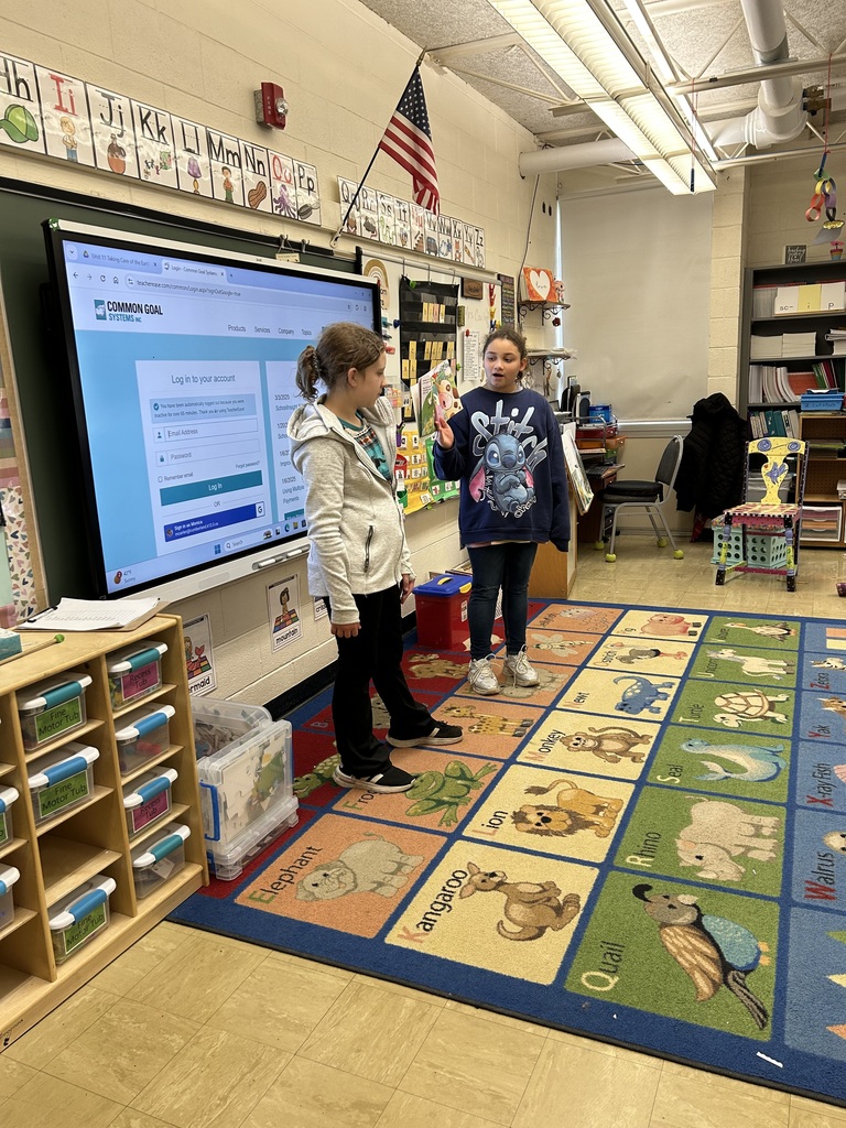 Kindness Ambassadors are reading a story to elementary students.