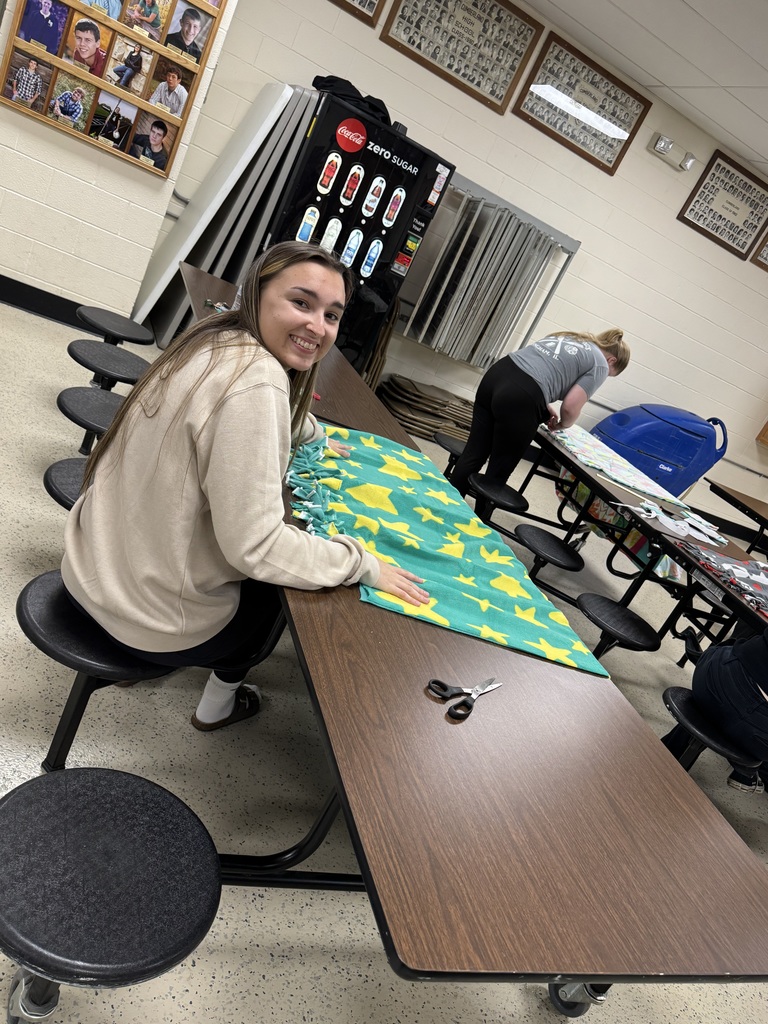 An NHS student is tying the blankets.