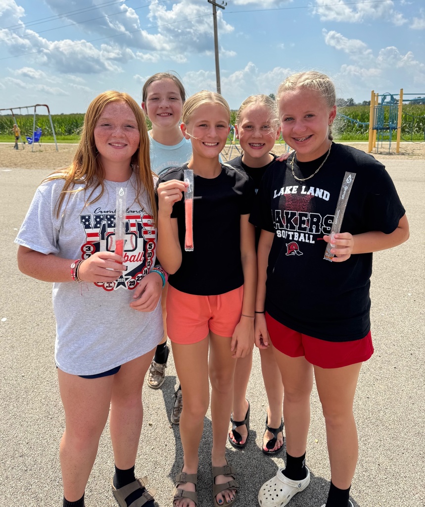 Five girls are eating popsicles. 