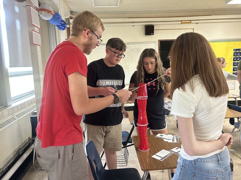 Students are collaborating to build a cup tower.