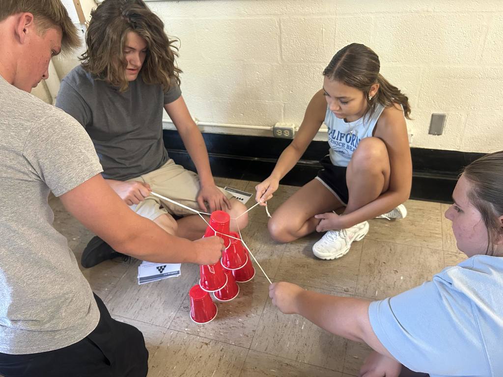 Students are collaborating to build a cup tower.