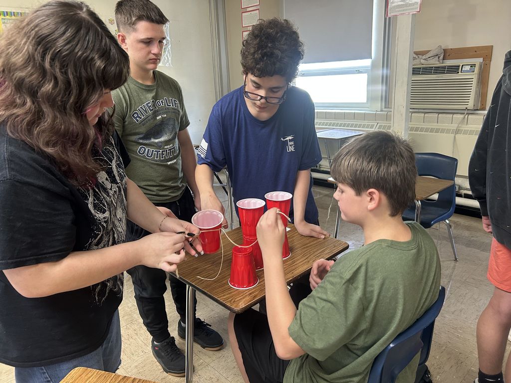 Students are collaborating to build a cup tower.