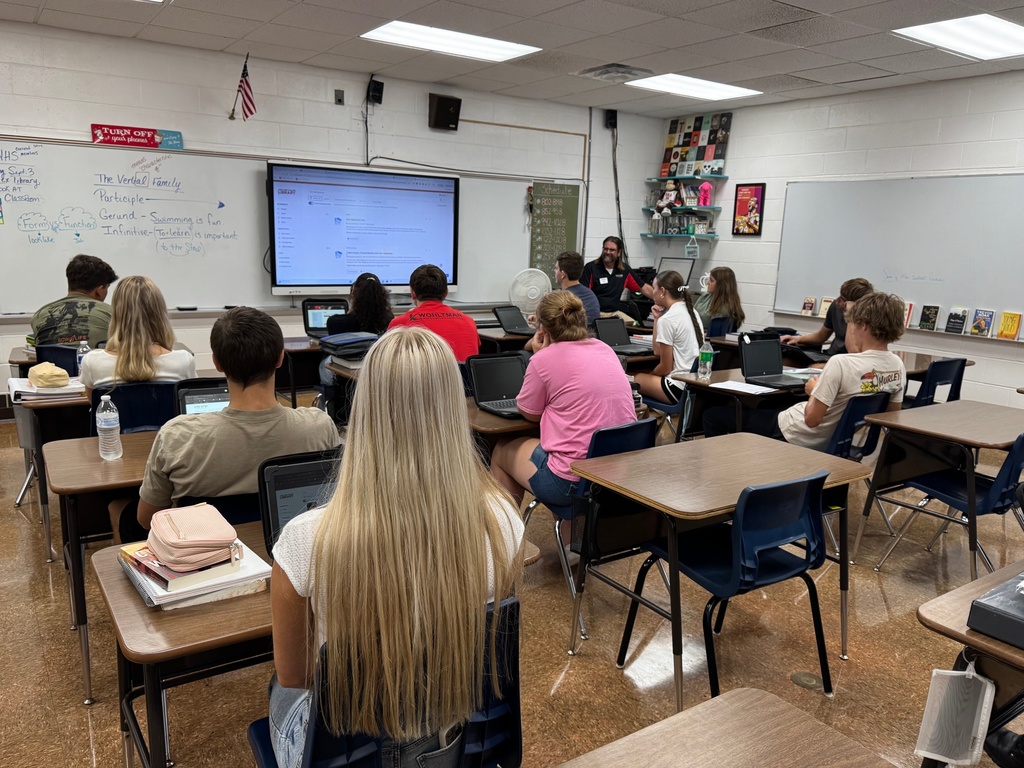 Mr. Cougill is teaching the dual credit students to use the library's database. 