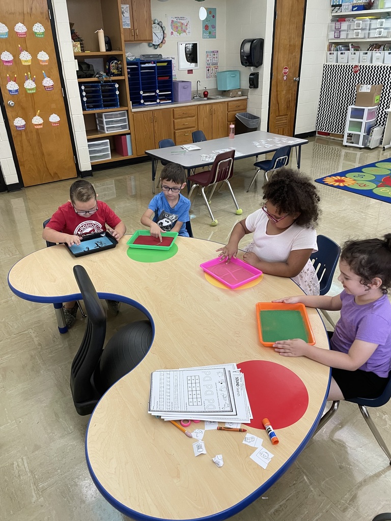 Students are writing their letters in the sand.