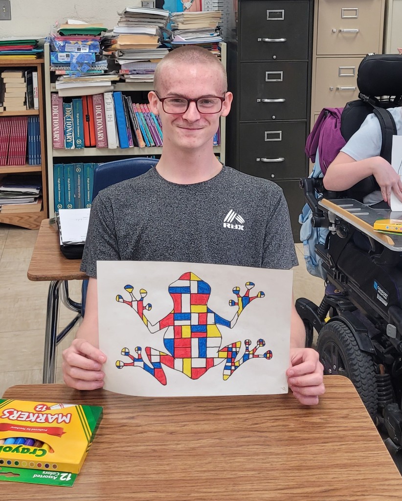 Student is holding his Mondrian art project.