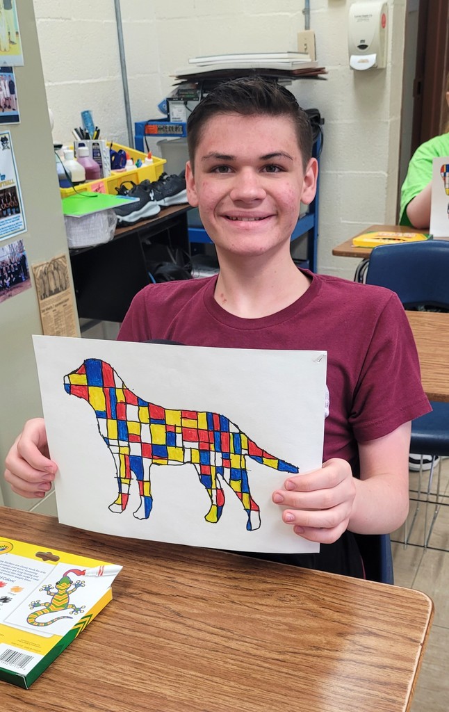 Student is holding his Mondrian art project.