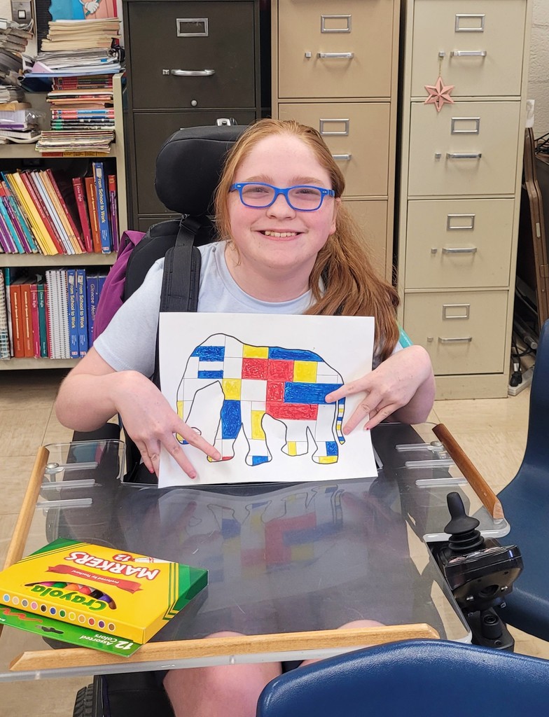 Student is holding her Mondrian art project.