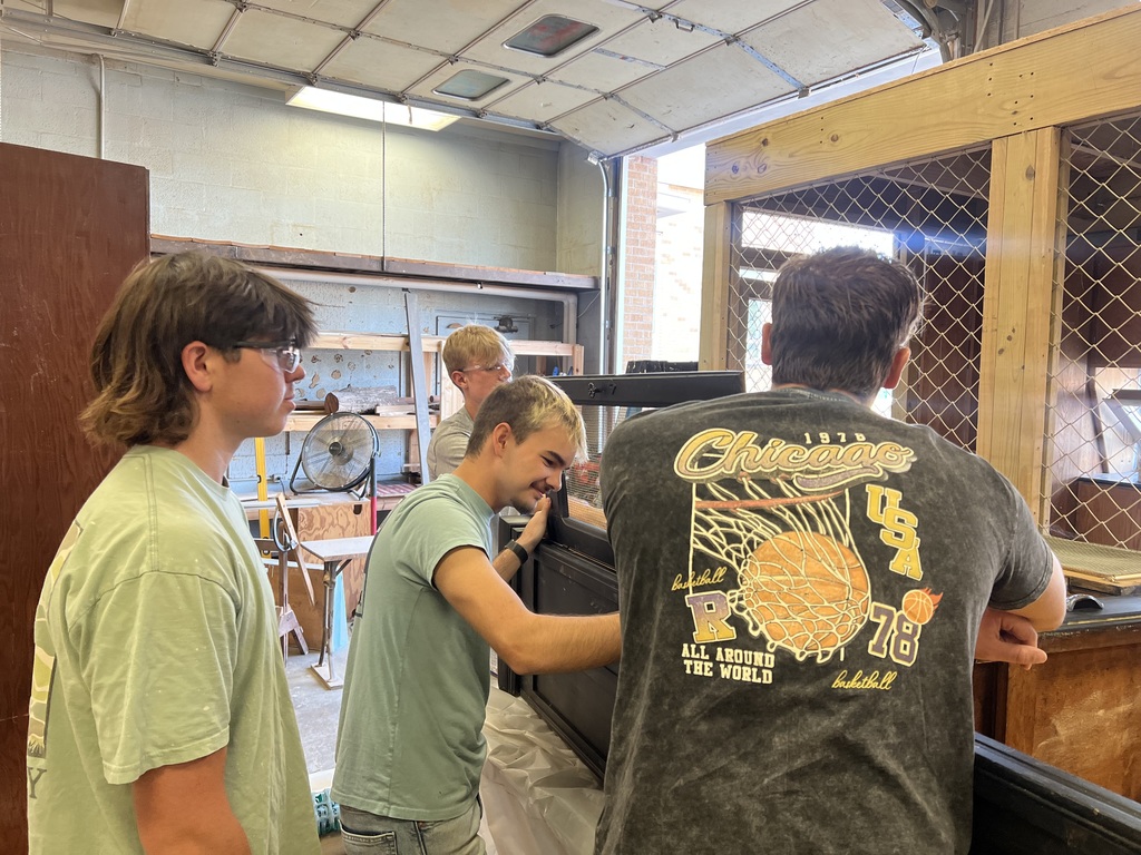 Students are preparing a cabinet to be refinished.
