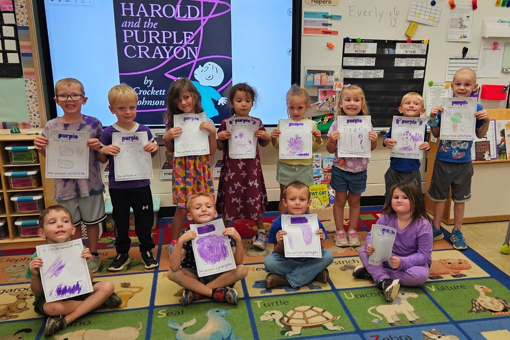 Mrs. Carlen's class is holding their purple pictures. 