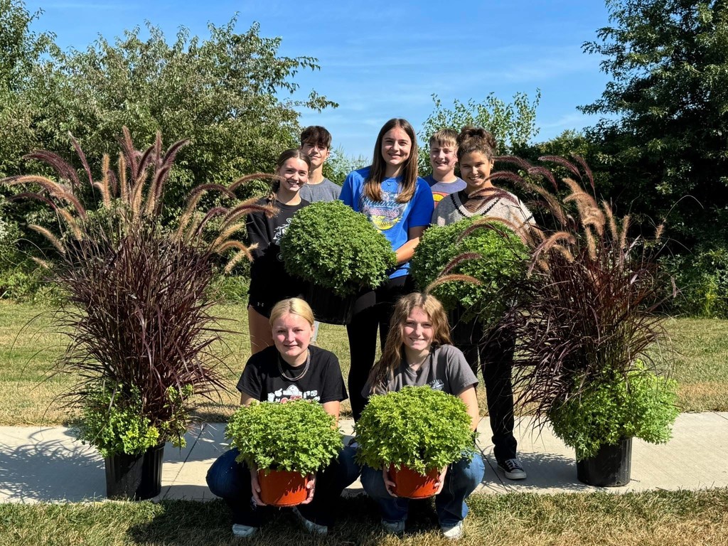 Seven FFA members are holding mums they are selling.
