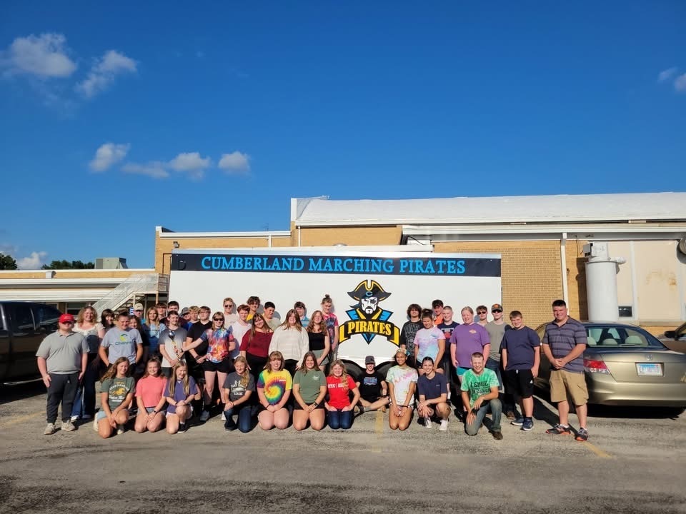 The band is standing in front of the trailor.