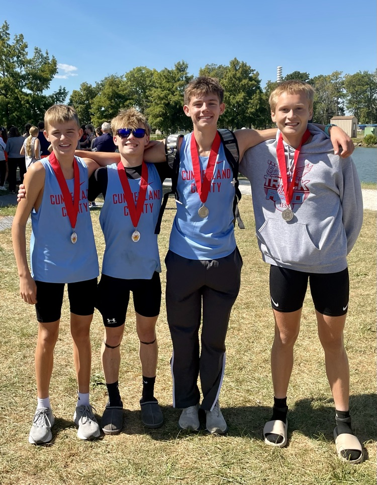 The 4 boys standing and wearing their medals  