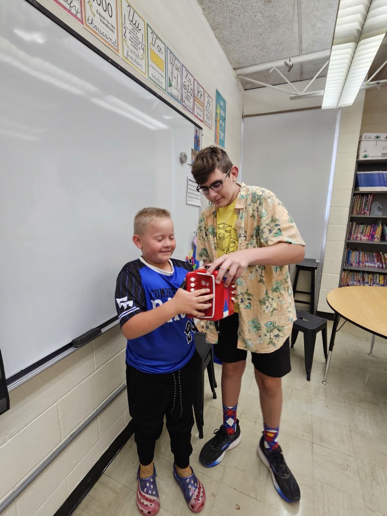 Brooks is showing a student how to play the accordian.
