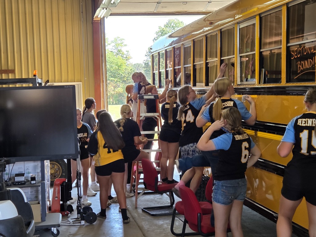 The Lady Raiders are painting the windows of their bus. 