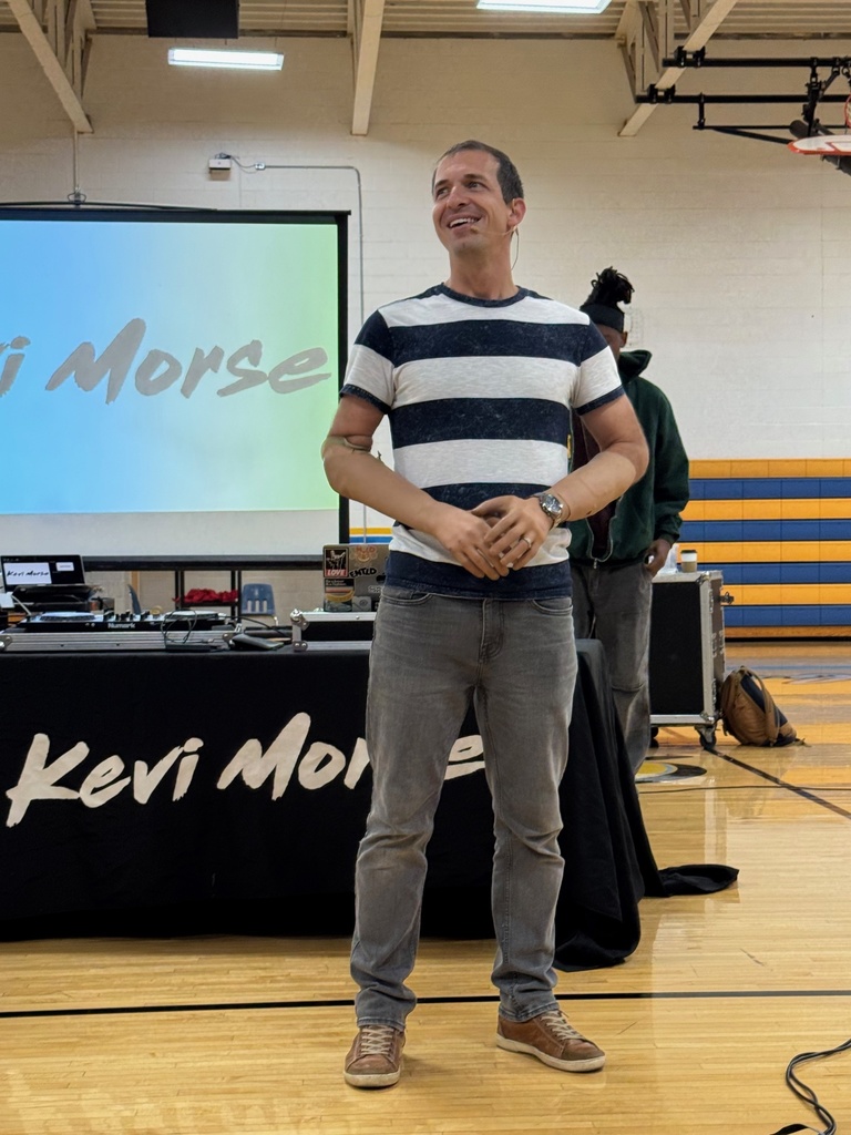 Brad is speaking to the students. Singer Kevi Morse is in the background. 