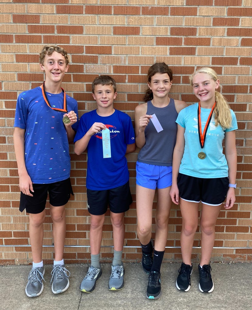 Varsity runners displaying their ribbons and medals. 