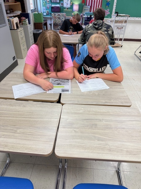 Students are working in groups to complete the work at each station. 