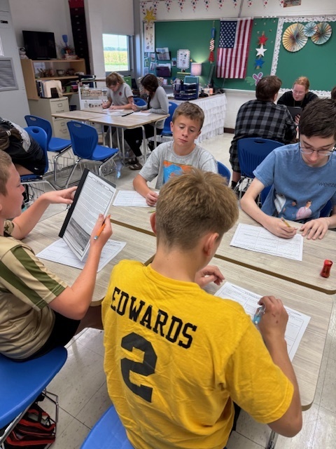 Students are working in groups to complete the work at each station. 