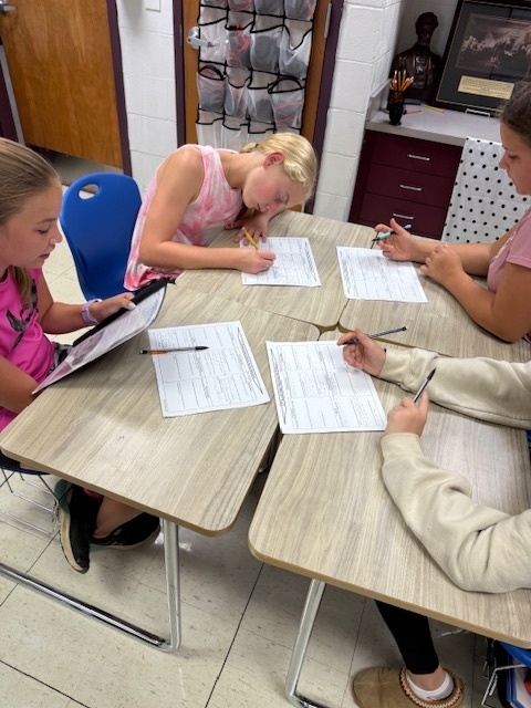 Students are working in groups to complete the work at each station. 