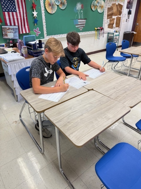 Students are working in groups to complete the work at each station. 