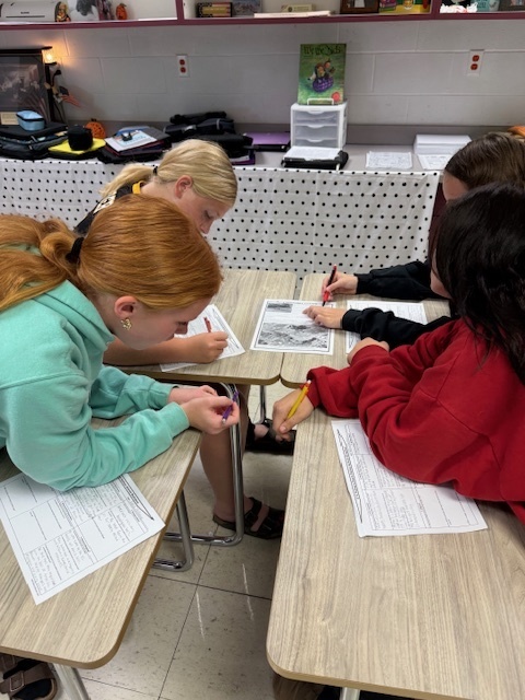 Students are working in groups to complete the work at each station. 