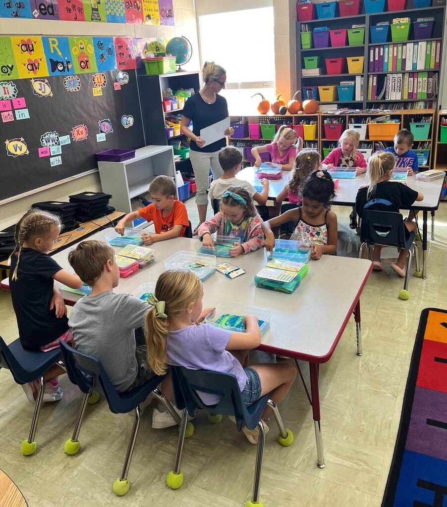 Students are writing their words in sand. 