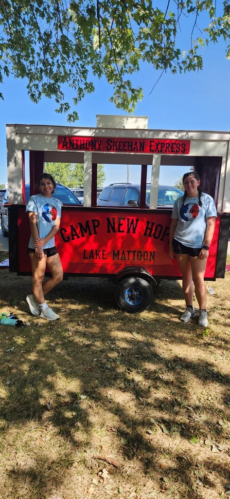 Two students are standing in front of a trolly.