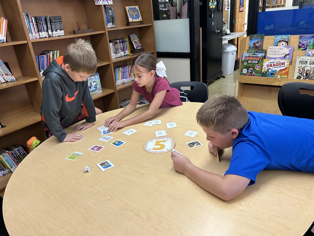 Students are matching call numbers to books. 