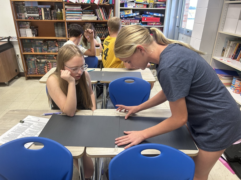 Two students are putting together their project.