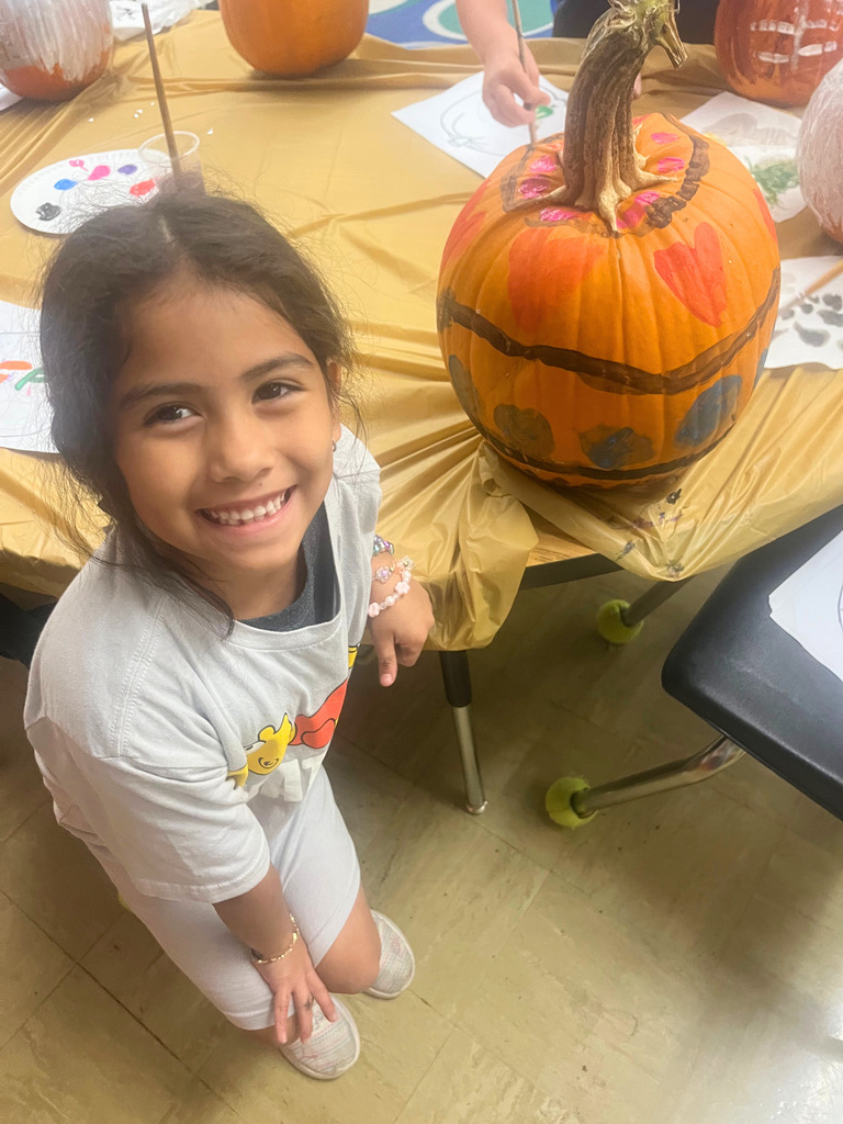 A student is posing with the pumpkin.