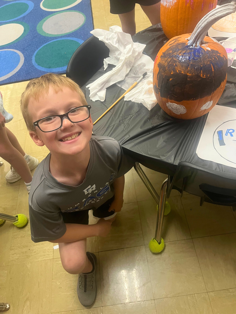 A student is posing with the pumpkin.