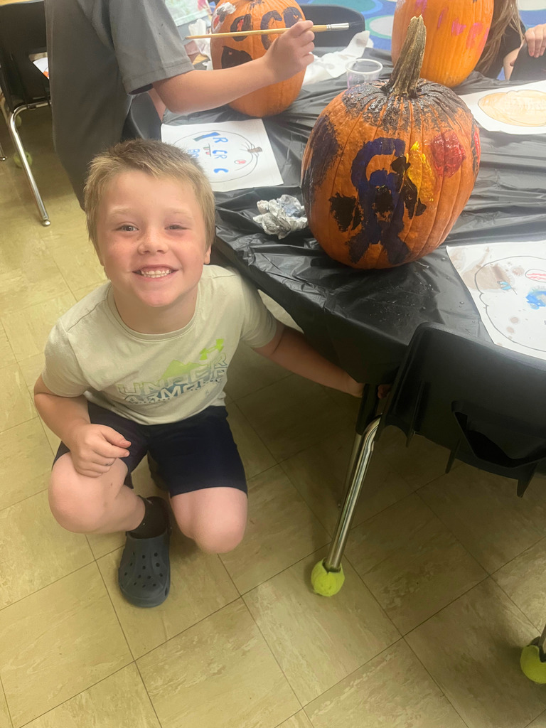 A student is posing with the pumpkin.