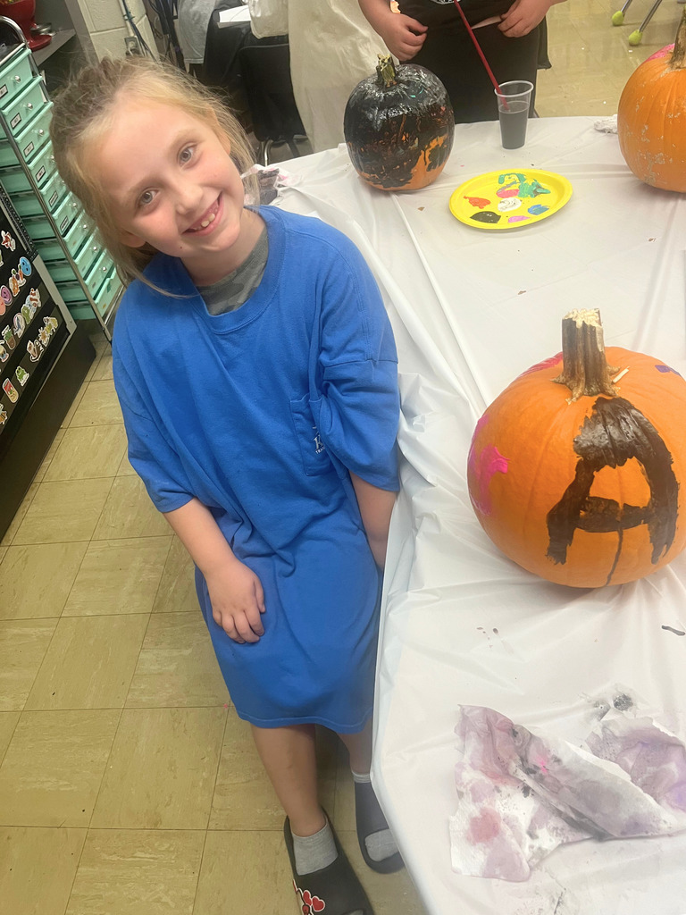 A student is posing with the pumpkin.
