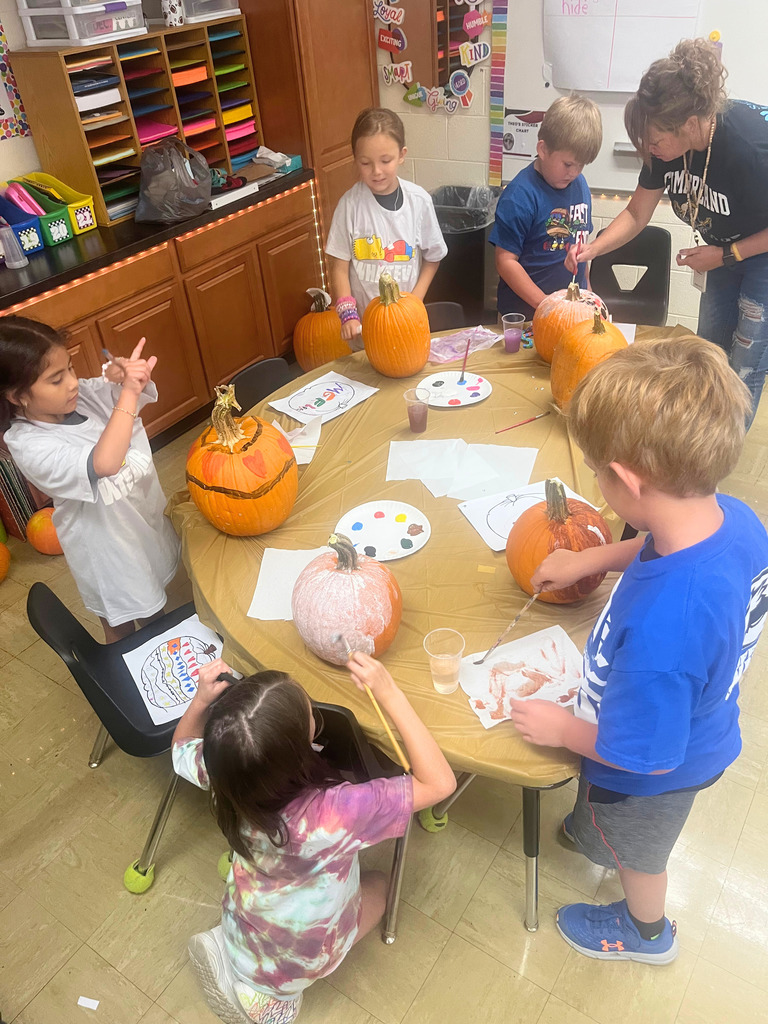 Students are painting their pumpkins. 