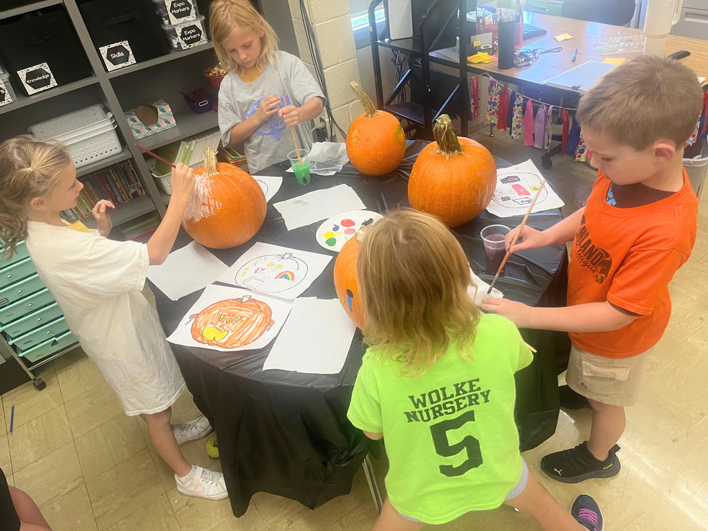 Students are painting their pumpkins. 